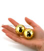 Gold Vibro Pleasure Balls holding both